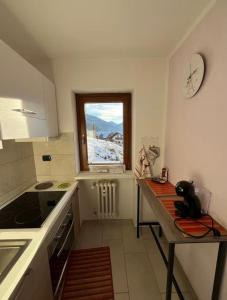 eine kleine Küche mit Tisch und Fenster in der Unterkunft Casa vacanze la primula erro in Sauze d'Oulx