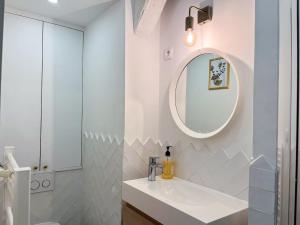 une salle de bain blanche avec un lavabo et un miroir dans l'établissement L'Oasis Rouennais - Hypercentre - Gare rive Gauche, à Rouen 26 autres photos