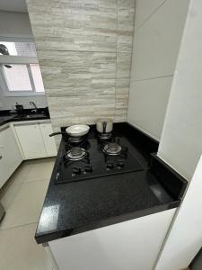 eine Küche mit einem Herd mit zwei Pfannen darauf in der Unterkunft Melhor apartamento de capão! 100m da praia in Capão da Canoa + 2 Fotos