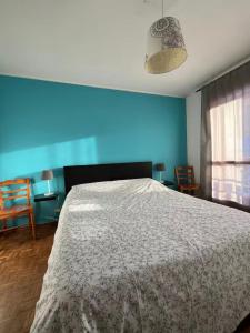 ein Schlafzimmer mit einem großen Bett mit einer blauen Wand in der Unterkunft Casa vacanze la primula erro in Sauze d'Oulx