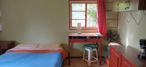 ein kleines Schlafzimmer mit einem Bett und einem Schreibtisch in der Unterkunft Puka ra in Colonia del Sacramento + 5 Fotos