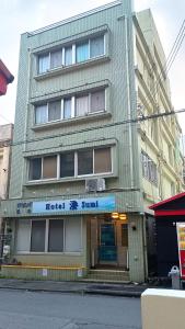a tall green building with a sign on it at Hotel-澄Sumi in Naha