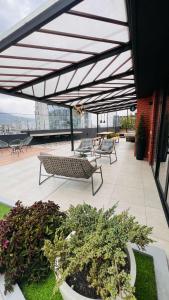 un patio con panchine e piante su un edificio di Departamento 2 dormitorios Quiteño Libre a Quito Altre 15 foto