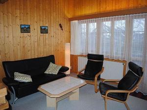 a living room with a couch and two chairs at Chalet Hofer in Hasliberg Wasserwendi