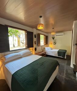 een slaapkamer met een groot bed en een groot raam bij Casa Monan, Atins beach in Atins