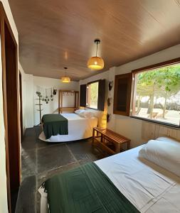 een hotelkamer met twee bedden en een raam bij Casa Monan, Atins beach in Atins