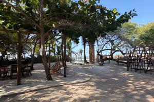 een picknickplaats met tafels en bomen op het strand bij Casa Monan, Atins beach in Atins