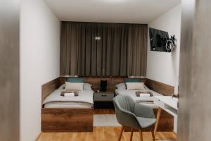 a hotel room with two beds and a chair at Apartmán Na Pomezí in Valtice