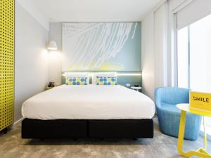 パースにあるibis Styles East Perthのベッドルーム1室(ベッド1台、青い椅子付)