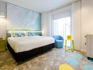 パースにあるibis Styles East Perthのベッドルーム(大型ベッド1台、青い椅子付)