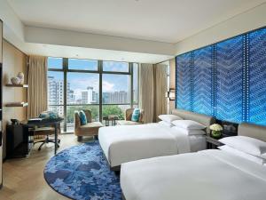 a hotel room with two beds and a desk at Sofitel Beijing Central in Beijing