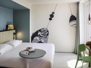 a bedroom with a white bed and a table at ibis Styles Arcachon Gujan Mestras in Gujan-Mestras +79 photos