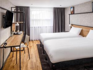 a hotel room with two beds and a desk at ibis Wakefield East-Castleford in Wakefield