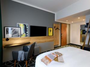 een hotelkamer met een bed en een flatscreen-tv bij Ibis Styles Aschaffenburg in Aschaffenburg