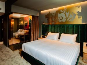 a bedroom with a large white bed and a mirror at Mercure Timisoara in Timişoara