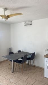 a dining room table with chairs and a ceiling fan at Apartment in Cupecoy