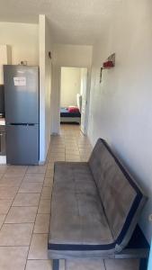 a couch sitting in a room with a refrigerator at Apartment in Cupecoy