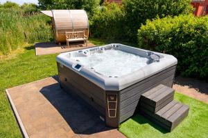 a hot tub in a yard with a chair at Ferienhaus Marvin In Beckerwitz in Gramkow