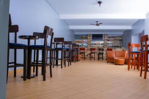 a bar with chairs and stools in a room at Noaz Hotel in Bulambiro