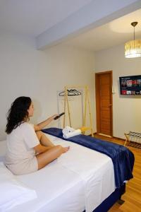 a woman sitting on a bed in a room at Barra Comfort Pousada in Salvador