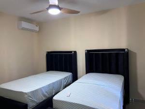 two beds in a room with a ceiling fan at Mi refugio 2 in San Fernando de Monte Cristi +5 photos
