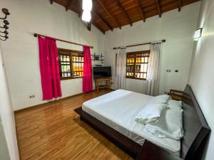 Schlafzimmer mit einem großen Bett und roten Vorhängen in der Unterkunft Casa Finca Villa Laura 158 in Rionegro