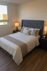 a bedroom with a large bed with two lamps and a window at Luxury apartment with panoramic view in tower in Laborcillas