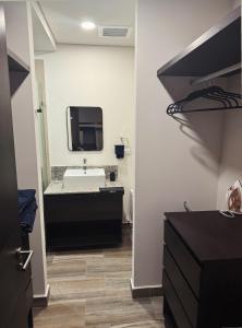 a bathroom with a sink and a tv on the wall at Luxury apartment with panoramic view in tower in Laborcillas