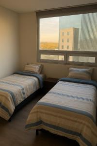 two beds in a room with a large window at Luxury apartment with panoramic view in tower in Laborcillas +20 photos