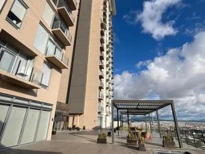 a building with a patio with tables and chairs at Luxury apartment with panoramic view in tower in Laborcillas