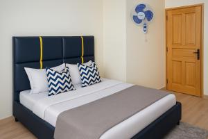 a bed with blue and white pillows in a room at Noaz Hotel in Bulambiro +14 photos