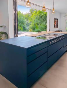 a blue island in a kitchen with a large window at Villa calme avec piscine et spa à Mérignac Proche hôpital tram et parc d activité in Mérignac