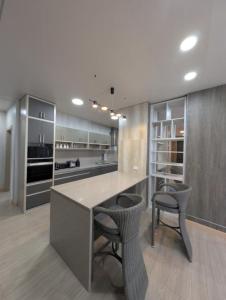 a kitchen with a counter with two chairs and a table at ICHA Apartments in Suva