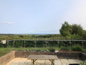 a picnic table on a patio with a view of a garden at Clonkellure house in Kilbrittain