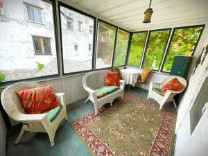 een afgeschermde veranda met stoelen en een tafel bij Historic Victorian Apartment in McGregor