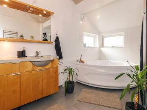 Un baño blanco con bañera y lavabo. en 4 star holiday home in Væggerløse, en Bøtø By 45 fotos más