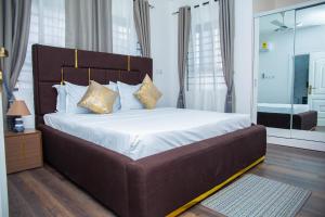 a bedroom with a large bed with white sheets and pillows at No4 Wisdom Court in Accra