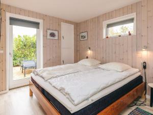 una cama grande en una habitación con ventana en 4 star holiday home in Væggerløse, en Bøtø By