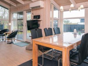 ein Esszimmer mit einem großen Holztisch und Stühlen in der Unterkunft 8 person holiday home in Ebeltoft-By Traum in Ebeltoft