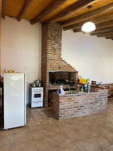 a kitchen with a brick fireplace and a white refrigerator at La Perla del Yuqueri in Concordia
