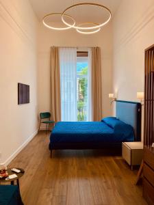 a bedroom with a blue bed and a window at Dimora Donna Maria Relais in Cava deʼ Tirreni