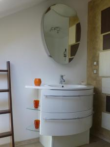 uma casa de banho com um lavatório e um espelho em chambres d'hôte Le Marronnier em Champrougier