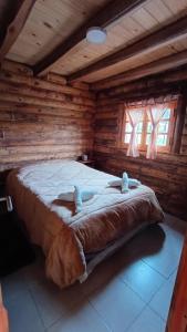 a bedroom with a bed in a log cabin at Cabañas Rústicas Entre Montañas in Tunuyán