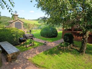 a barbecue grill and a bench in a yard at Rezidence Jih in Hlavňovice