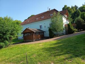 a white house with a brown roof and a yard at Rezidence Jih in Hlavňovice