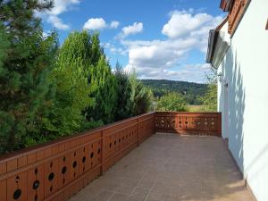 a balcony with a wooden fence and trees at Rezidence Jih in Hlavňovice +11 photos