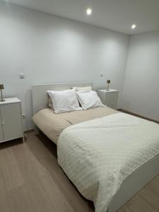 a bedroom with a large bed with white sheets and pillows at Chambre Élégance et confort a Esch in Esch-sur-Alzette
