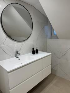 a bathroom with a white sink and a mirror at Chambre Élégance et confort a Esch in Esch-sur-Alzette