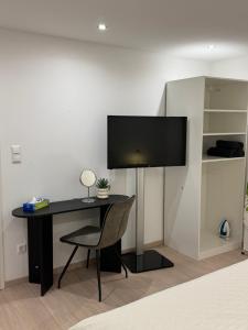 a desk with a monitor and a chair in a room at Chambre Élégance et confort a Esch in Esch-sur-Alzette