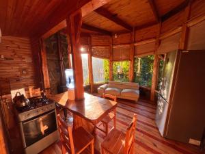 a kitchen and living room of a log cabin at Reserva los Bollenes in Constitución